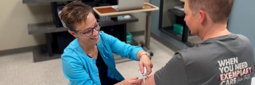 Ann measuring a patients arm swelling. 