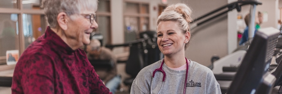 A nurse in cardiac rehab monitoring a patient.