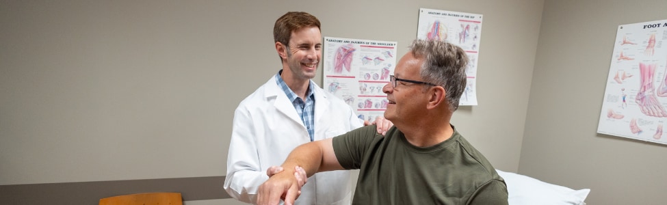 Dr. John Lammli, orthopedic surgeon, examining a patient's shoulder.