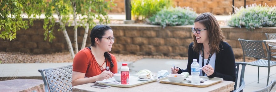 Two Faith Health employees sitting outside eating lunch