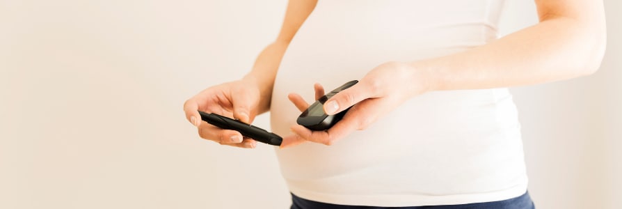 pregnant woman checking her blood sugar