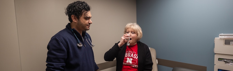 Dr. Khalil with pulmonology patient holding an inhaler