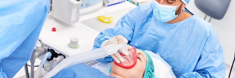 Anesthesiologist administering anesthetic.