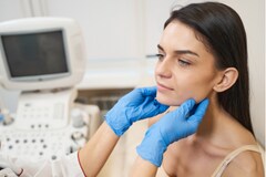 Female patient having her thyroid examined