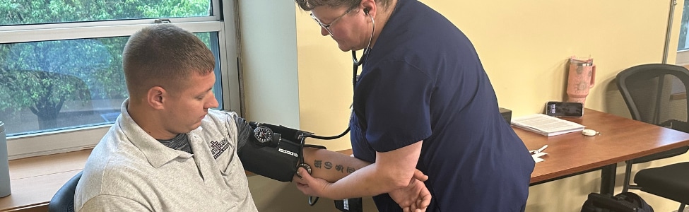 An occupational medicine nurse performing an employee health screening.