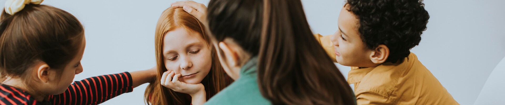 Sad young girl with friends supporting her