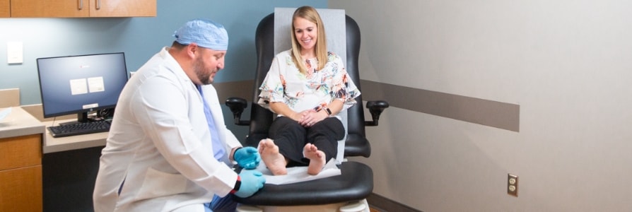 Dr. Zackary Gangwer, a foot and ankle surgeon, examining a patient's foot.