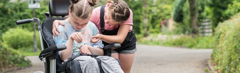 Young girl with spasticity spending time with her friend.